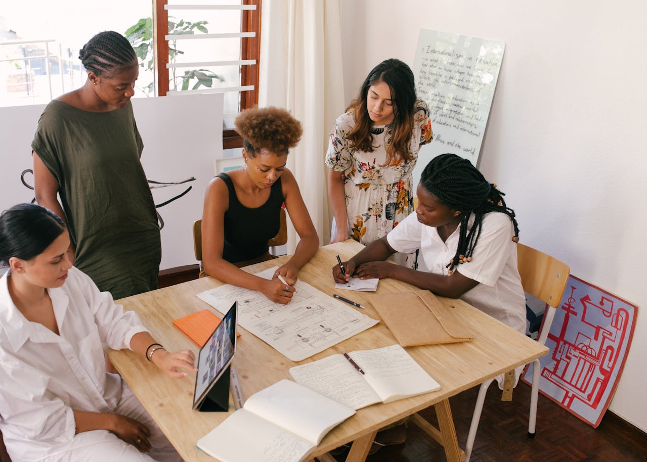 Entrepreneurs gathering at a table to discuss their plans