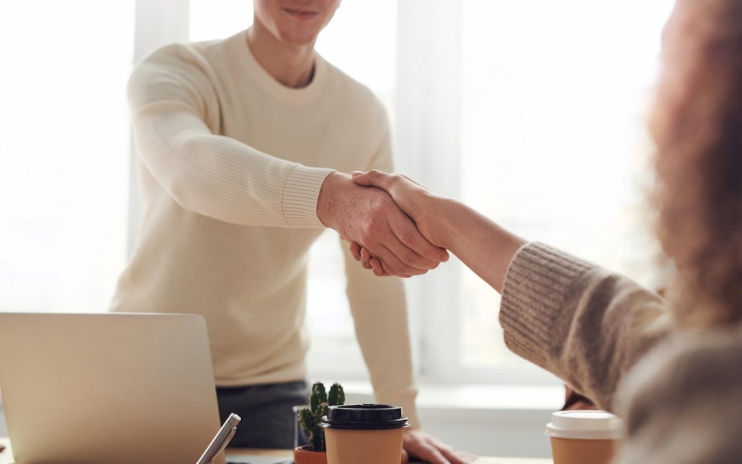 A man reaching out his hand to shake a woman's hand in partnership