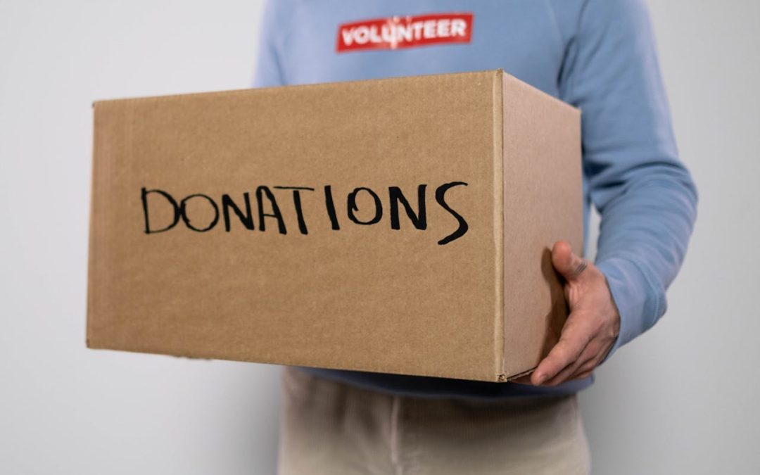 a person holds a cardboard donation box